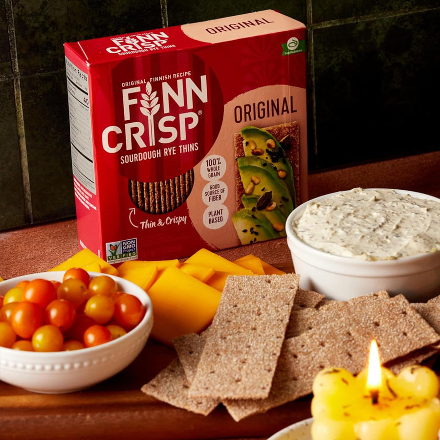 a box of finn crisps behind a spread of dip and thins